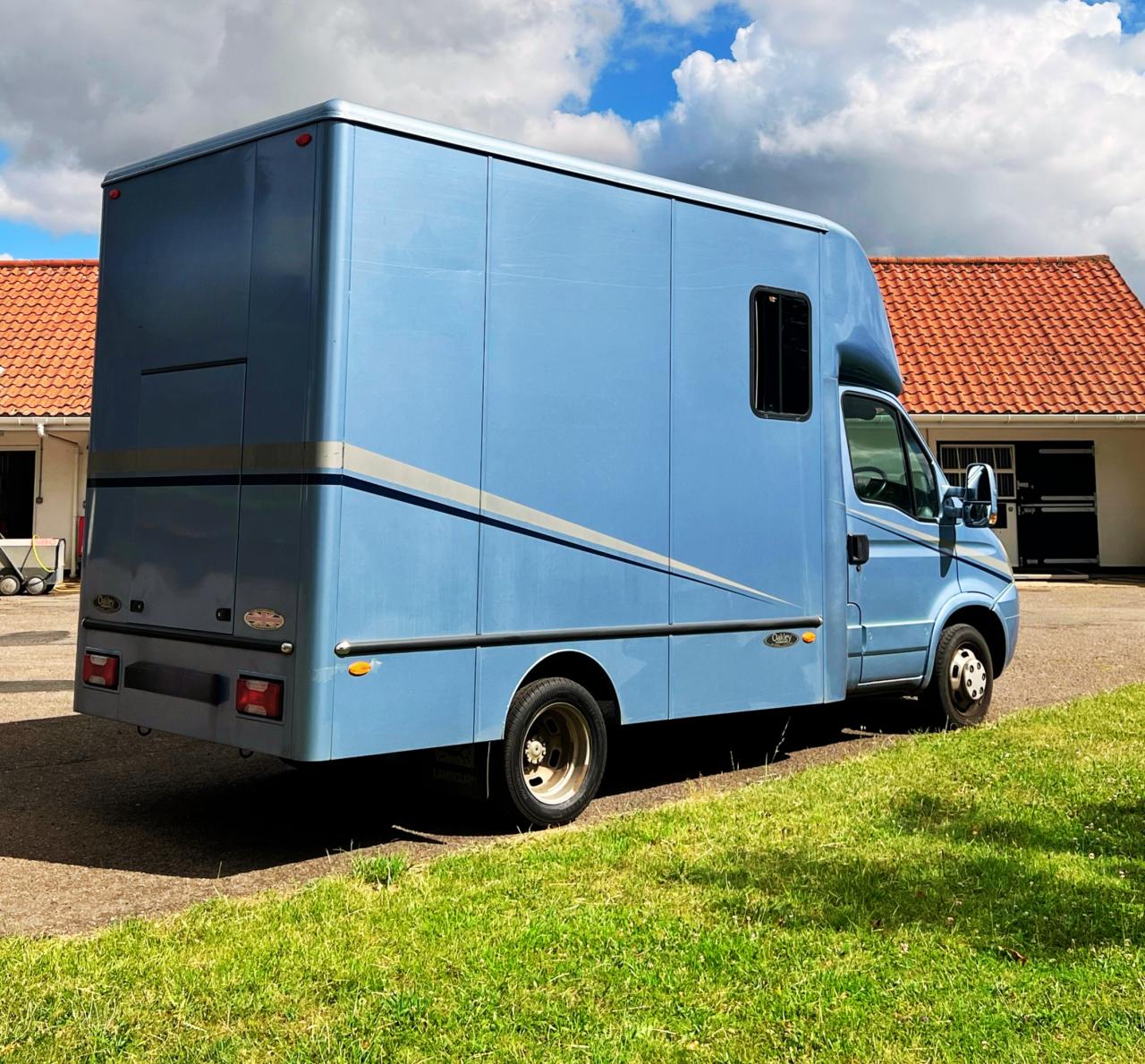 A horse box parked near a yard.